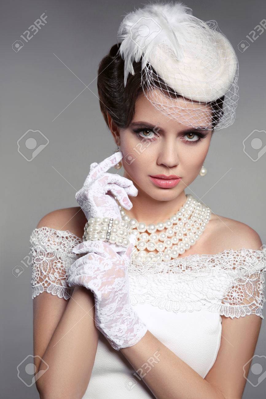Portrait élégant à La Mode De Femme. Style De Mariage. Beauté Modèle Brune  En Gants Blancs Et Chapeau, Collier De Perles Regardant La Caméra Sur Fond  Gris. Banque D'Images Et Photos Libres