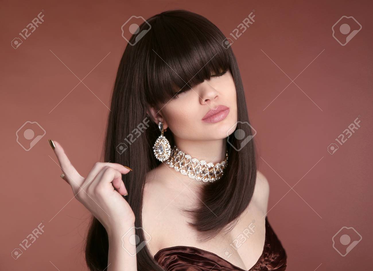 美しさのボブヘア 流行の髪型 ファッションのマニキュア ゴージャスな若い黒髪の女性の肖像画 官能的な唇のメイクアップ 手入れされた爪が黄金のポーランド の写真素材 画像素材 Image