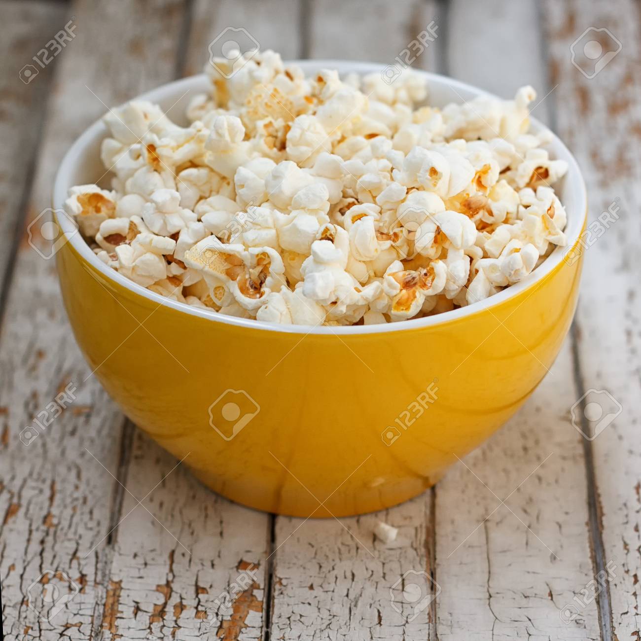 白の木製テーブルの上の黄色いボールで新鮮なポップコーン 選択と集中 の写真素材 画像素材 Image