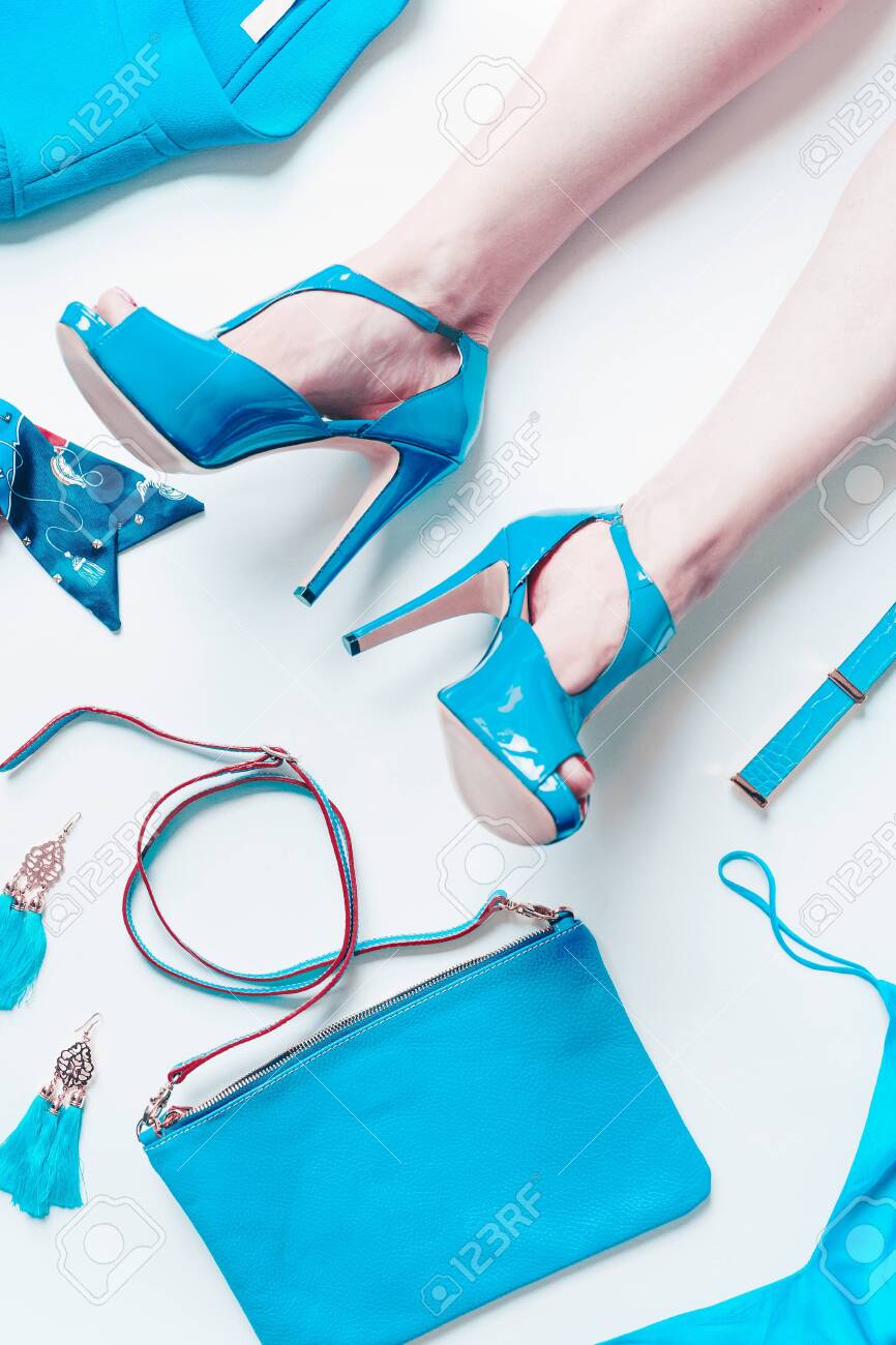 Woman Legs In Sexy Turquoise Bright Pumps Lie On White Floor