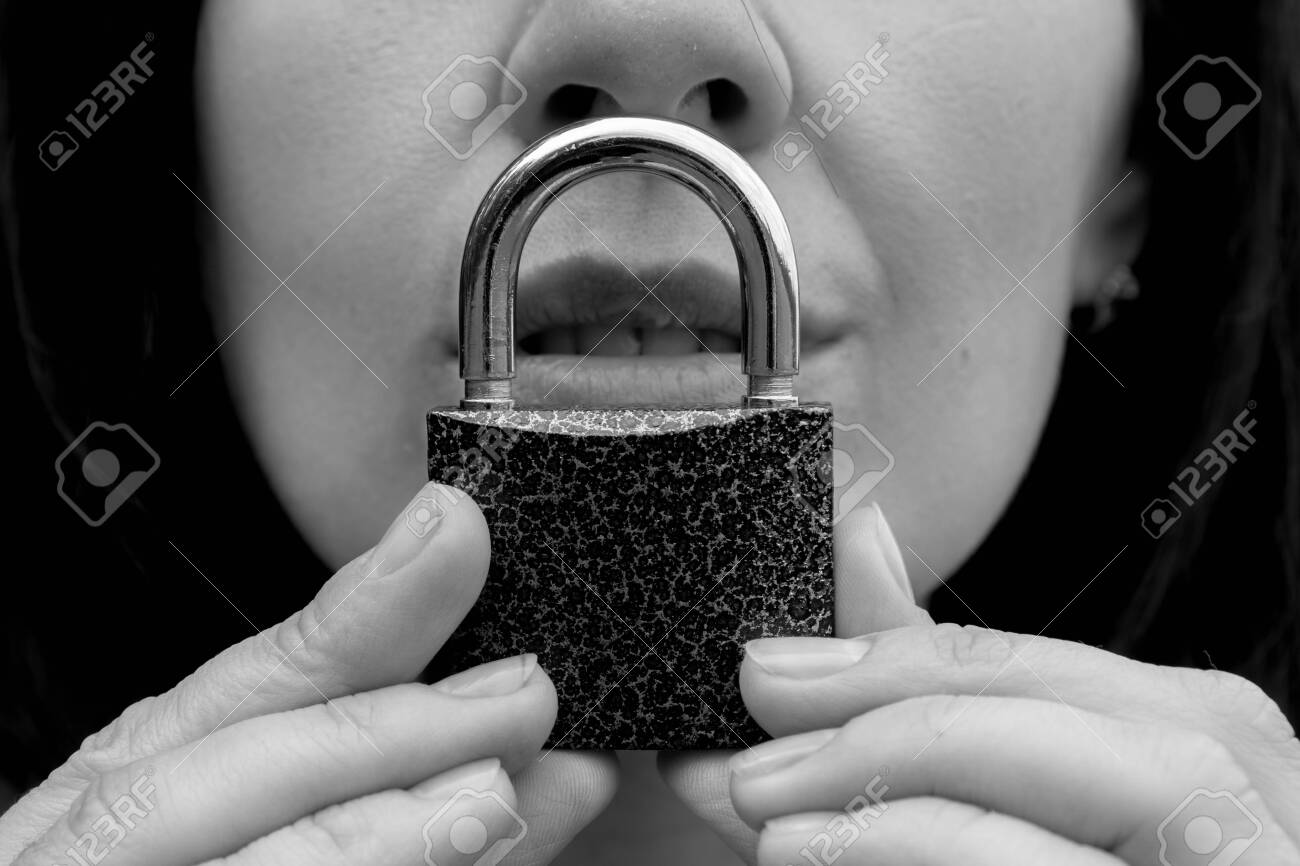 Conceptual portrait of a woman keeping silence with lock over her mouth. caucasian woman keep mouth locked. Language barrier concept and protecting the rights of women. Black and white. - 129085952 Conceptual portrait of a woman keeping silence with lock over her mouth. caucasian woman keep mouth locked. Language barrier concept and protecting the rights of women. Black and white. - 129085952