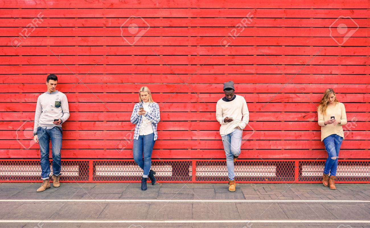 Group of multiracial fashion friends using smartphone with red wood background - Technology addiction in urban lifestyle with disinterest towards each other - Addicted people to modern mobile phones - 54114006 Group of multiracial fashion friends using smartphone with red wood background - Technology addiction in urban lifestyle with disinterest towards each other - Addicted people to modern mobile phones - 54114006
