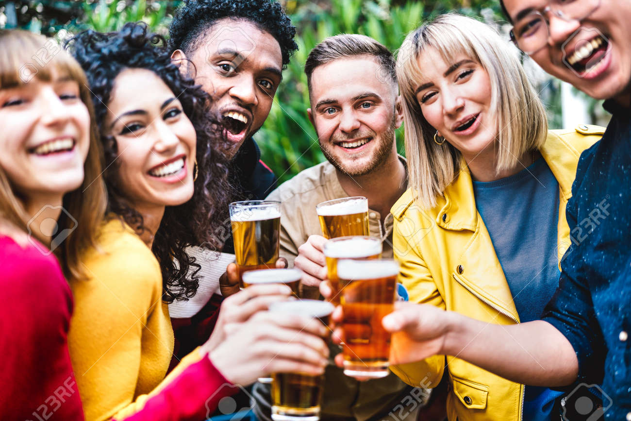Happy friends toasting beer at brewery bar dehor - Friendship life style concept with young millennial people enjoying time together at open air pub - Warm vivid filter with focus on central guy - 168285654 Happy friends toasting beer at brewery bar dehor - Friendship life style concept with young millennial people enjoying time together at open air pub - Warm vivid filter with focus on central guy - 168285654