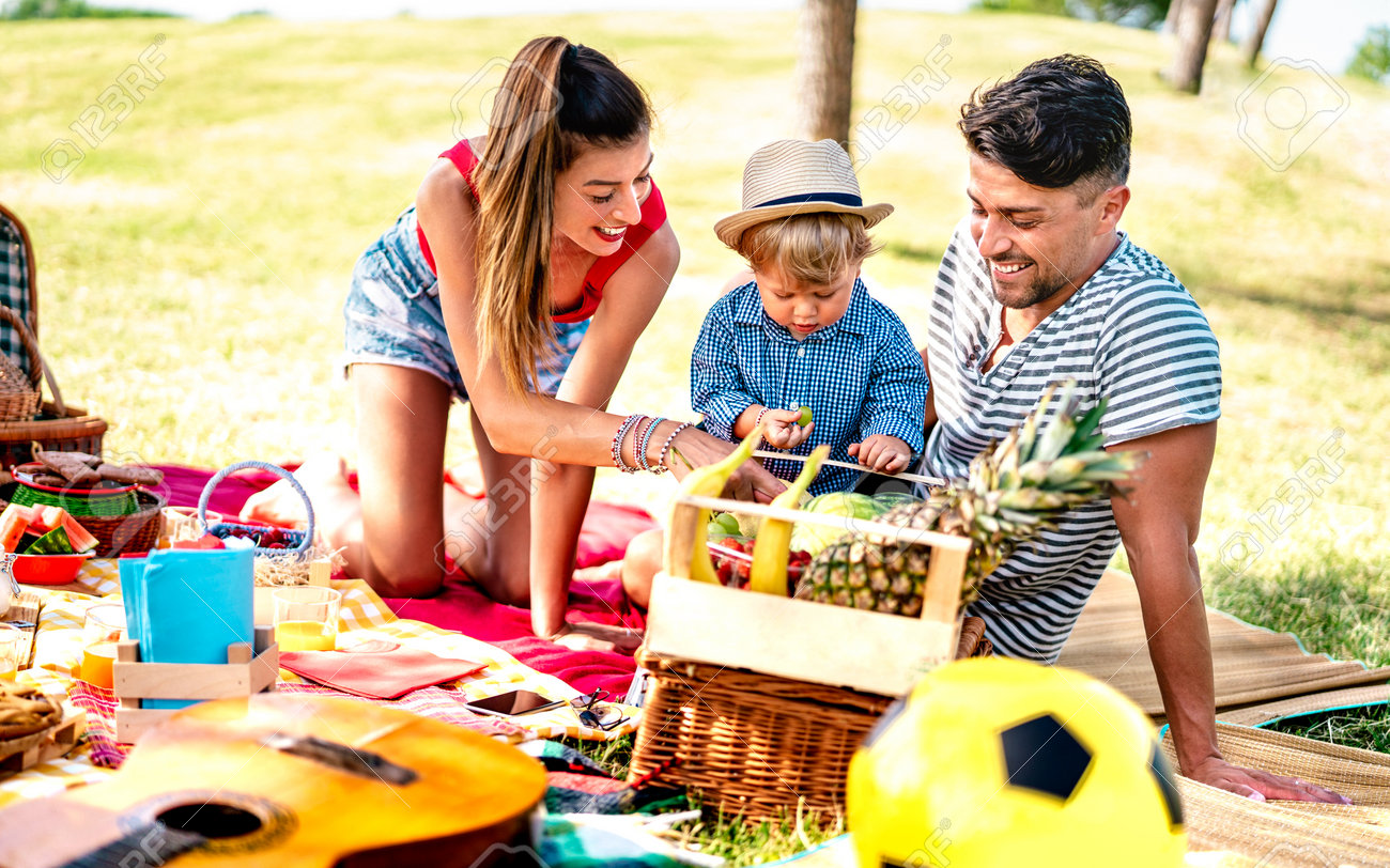 Happy family having fun together at picnic party - Joy and love life style concept with mother and father playing with child at park - Warm bright filter with focus on faces - 169667492 Happy family having fun together at picnic party - Joy and love life style concept with mother and father playing with child at park - Warm bright filter with focus on faces - 169667492