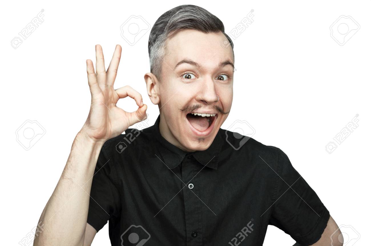 a guy in a black shirt with an open mouth shows a sign okay stock