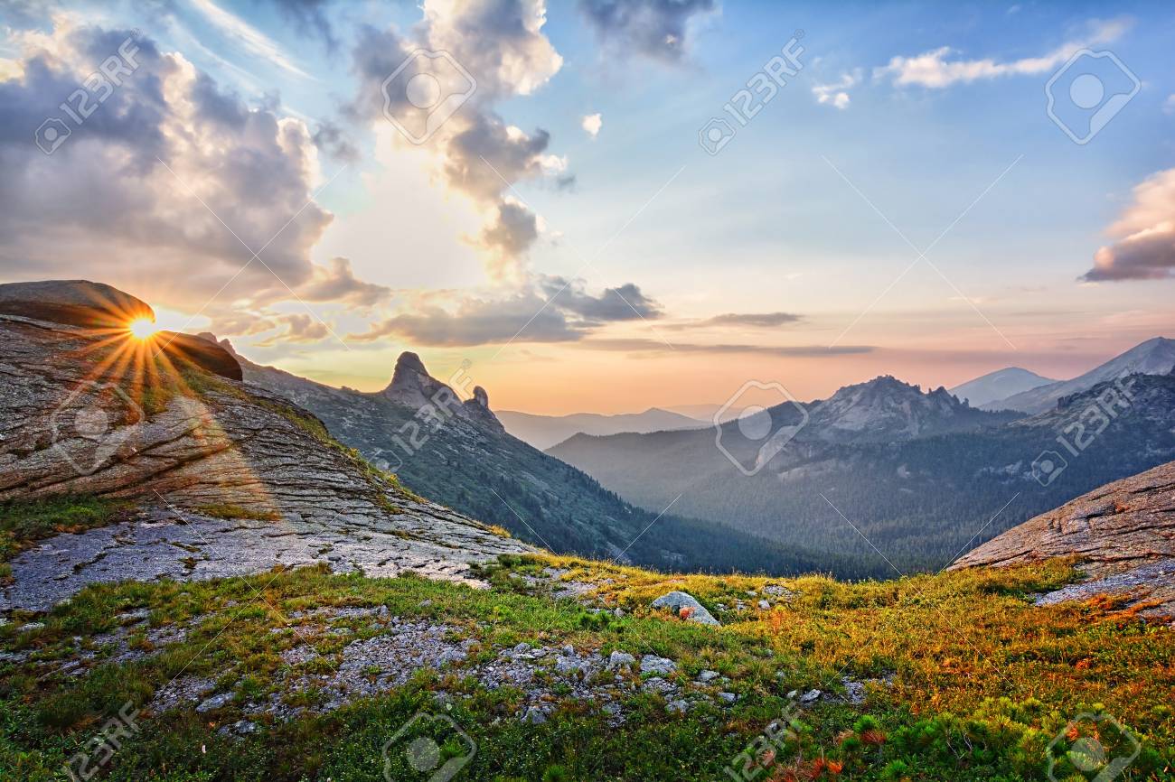 Beautiful Sunset Landscape Of Summer Picturesque Mountains With Sunlight On  Blue Cloudy Sky Background Stock Photo, Picture And Royalty Free Image.  Image 105910955.