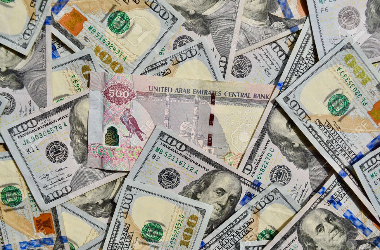 UAE National Banknote On Top Of USA National Currency, Top View Of Mixed  American Dollars Banknotes. UAE And USA Paper Money. 500 Dirhams And US  Dollars Exchange Rate. USD, AED Stock Photo,