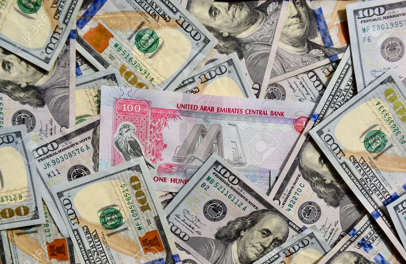UAE National Banknote On Top Of USA National Currency, Top View Of Mixed American  Dollars Banknotes. UAE And USA Paper Money. 100 Dirhams And US Dollars  Exchange Rate. USD, AED Stock Photo,