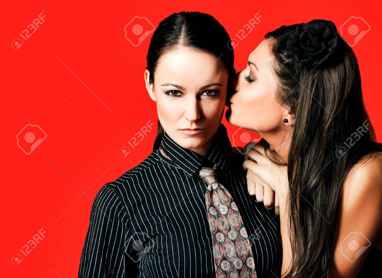 同性愛者の女性カップル 頬 赤い背景に他のキス の写真素材 画像素材 Image