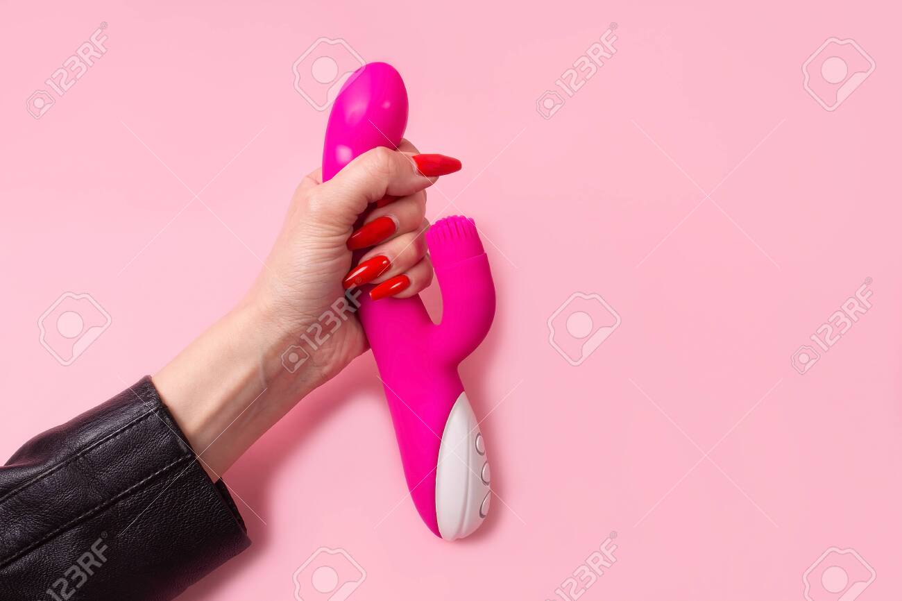 분홍색 배경에 손에 있는 딜도, 장난감 로열티 무료 사진, 그림, 이미지 그리고 스톡포토그래피. Image 151103920