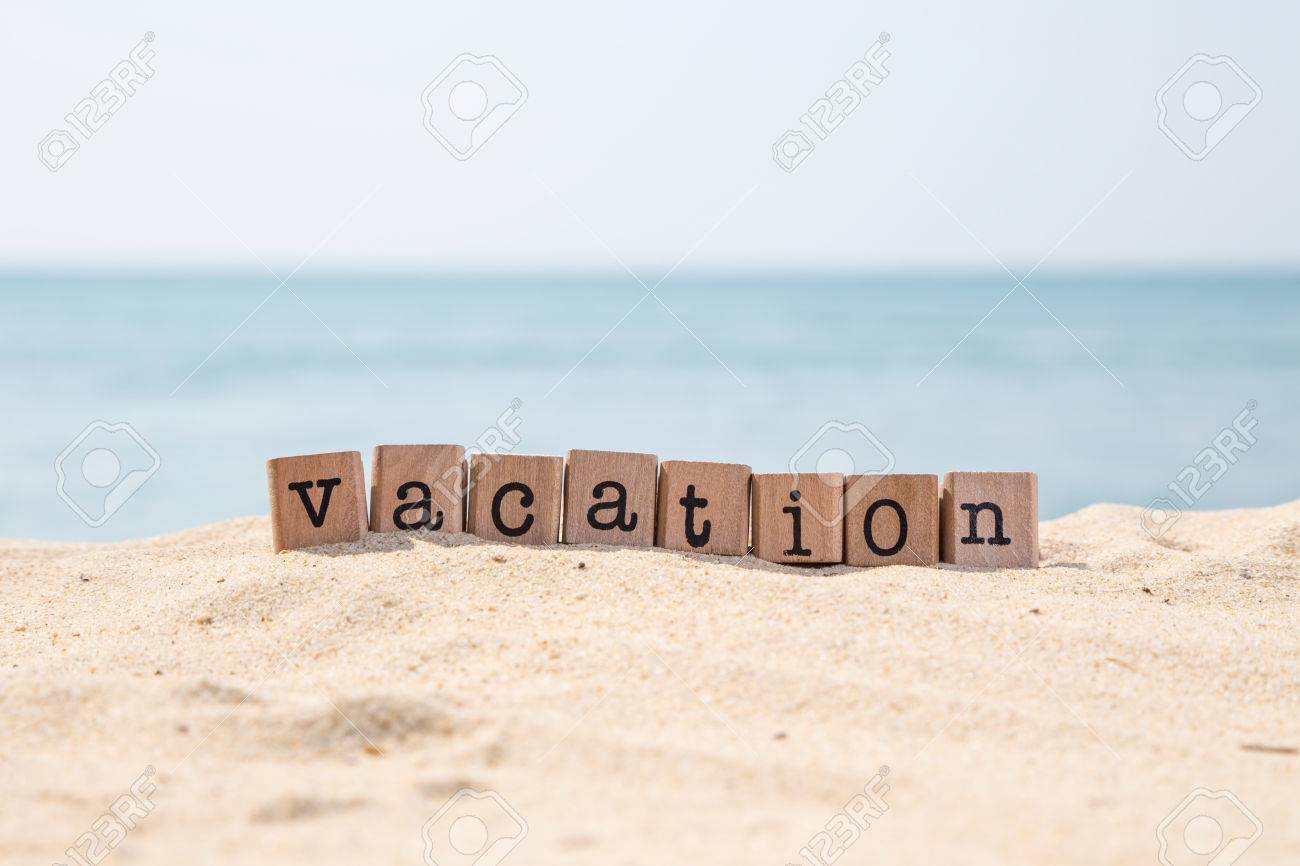 vacation word on wood rubber stamps stack on the sand beach for vacation word