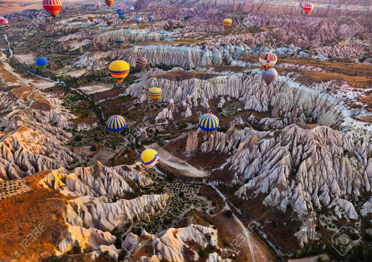 Hot air balloon flying over rock landscape at Cappadocia Turkey - 41129020 Hot air balloon flying over rock landscape at Cappadocia Turkey - 41129020