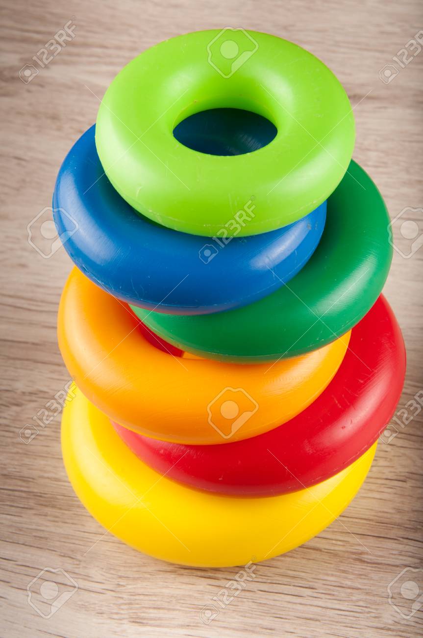 pyramid of different size and color toy plastic rings on wooden