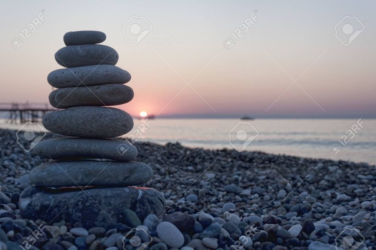 pyramid of pebbles on the beach against the backdrop of the rising