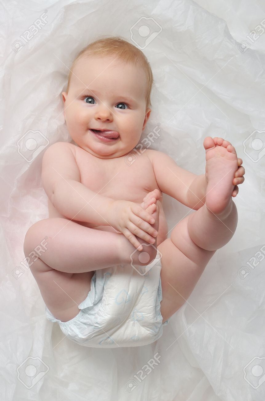 Cute Happy 7 Month Baby Girl In Diaper Lying And Playing Stock Photo