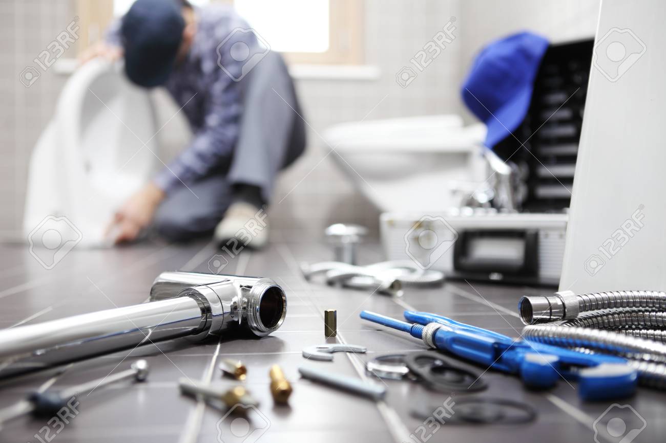 plumber at work in a bathroom, plumbing repair service, assemble and install concept. - 95572070 plumber at work in a bathroom, plumbing repair service, assemble and install concept. - 95572070