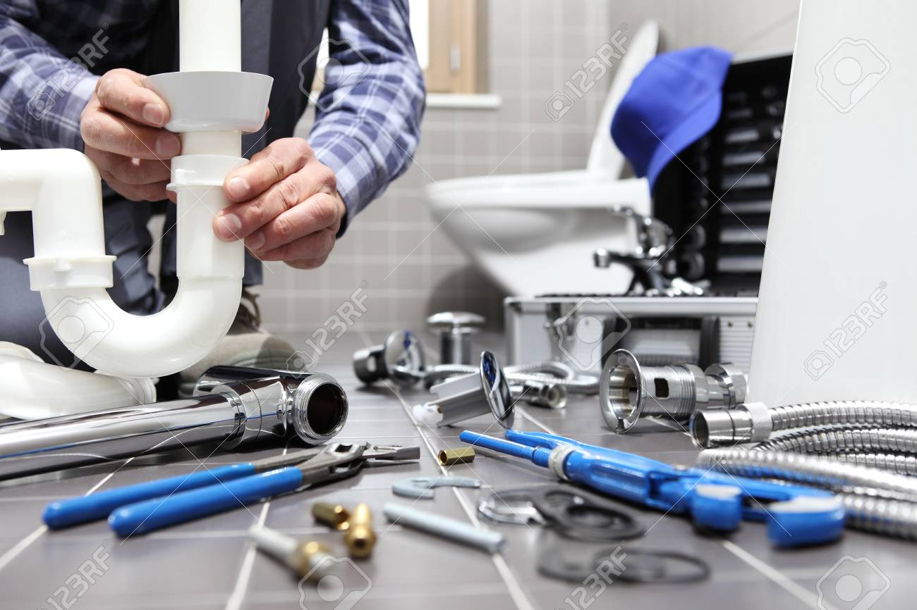 plumber at work in a bathroom, plumbing repair service, assemble and install concept. - 99466254 plumber at work in a bathroom, plumbing repair service, assemble and install concept. - 99466254