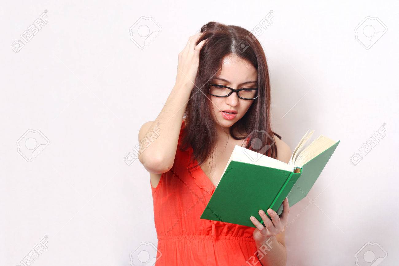 young brunette concentrated woman with glasses reading a book