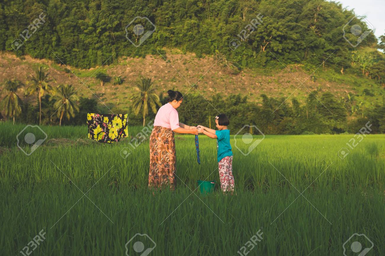 農村アジアの母と娘は、森の中で自分の服を乾燥させるのに役立っています。の写真素材・画像素材 Image 87878853