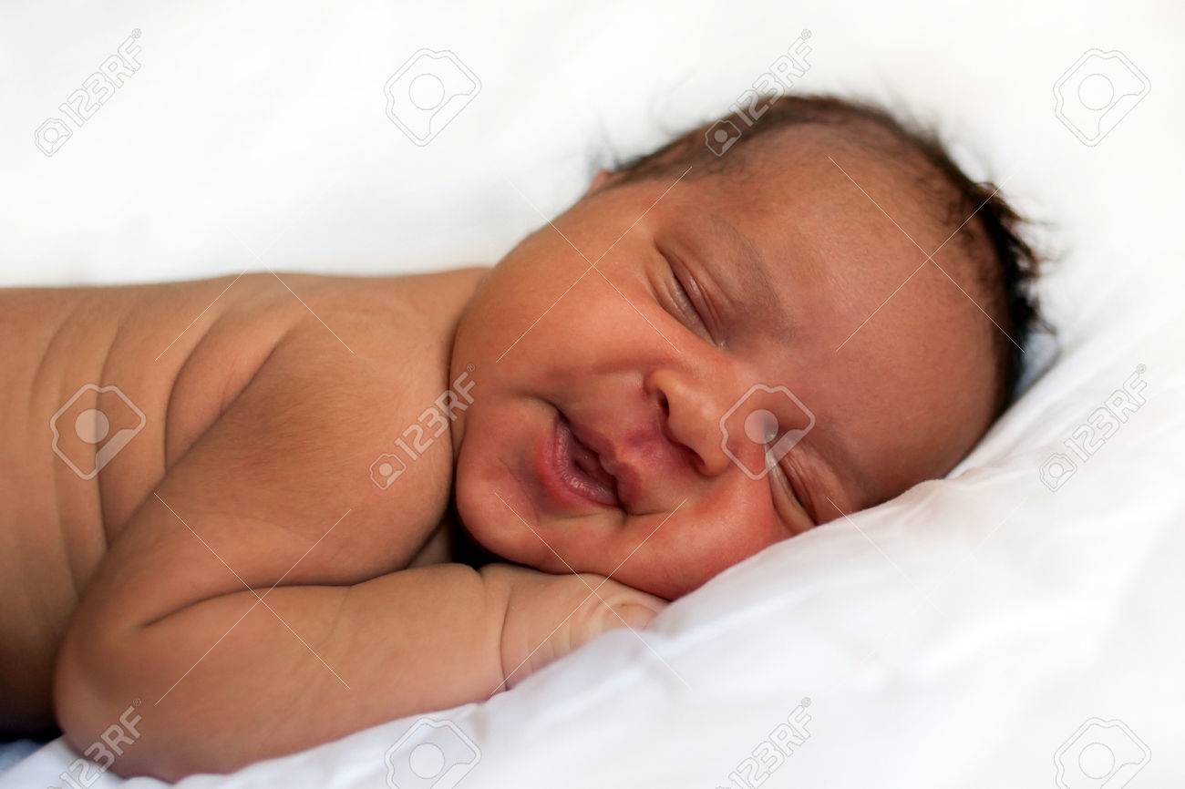 Black newborn baby sleeping soundly and peacefully stock photo 52191115