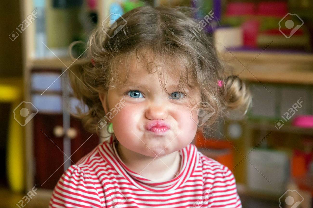 Funny portrait of adorable baby girl. Child makes grimaces face - 59700972 Funny portrait of adorable baby girl. Child makes grimaces face - 59700972