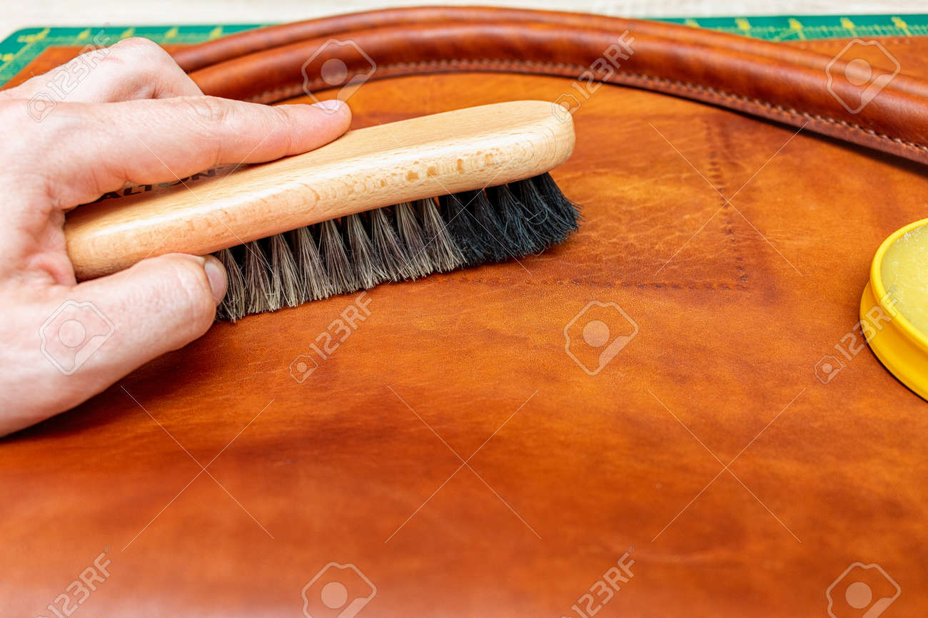 Polishing handmade leather bag with brush and wax - 157265513 Polishing handmade leather bag with brush and wax - 157265513