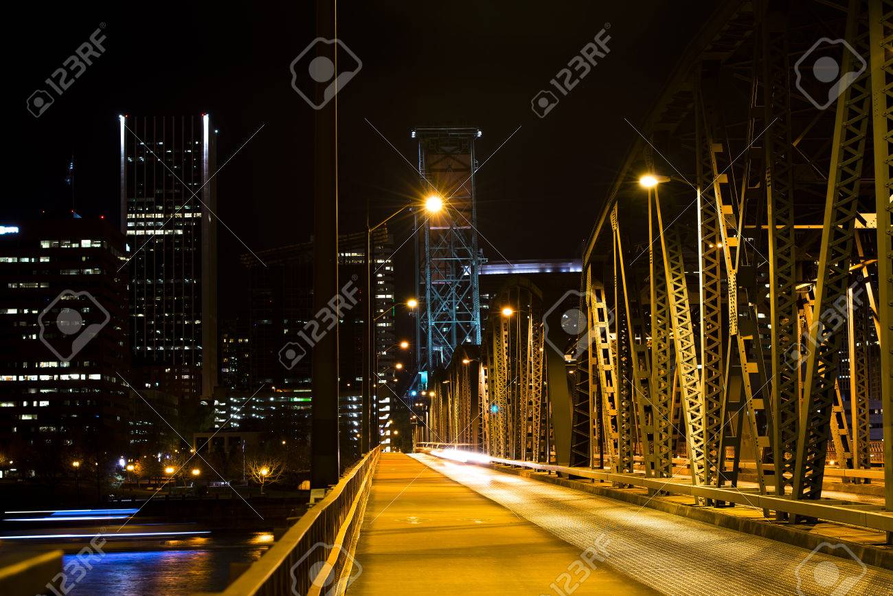夜のライトの船の通過繁華街にぼやけたシルエットの背景に川を渡ってサポート 2 つの塔を持つ金属の跳ね橋を点灯して夜のライト の写真素材 画像素材 Image