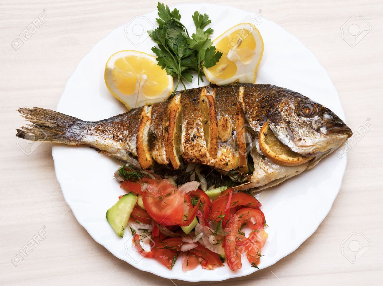 cooked fish sea bream fish with lemon parsley garlic stock photo