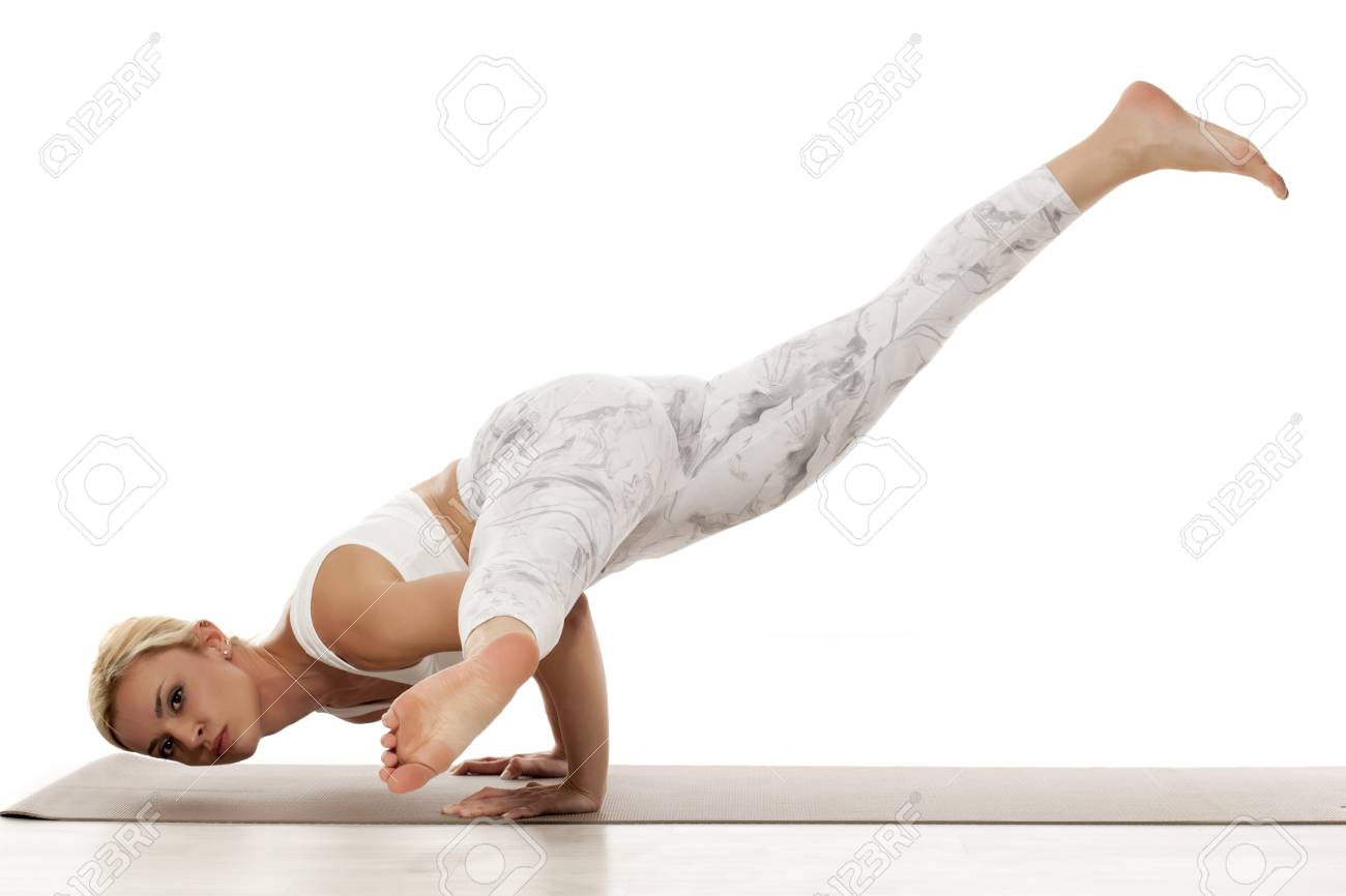 スプリットレッグアームバランス エカ パダ クンディニアサナヨガ スポーツ トレーニング ライフスタイルコンセプト ヨガエクササイズをしている白いスポーツウェアを着た若いブロンドの女性 の写真素材 画像素材 Image