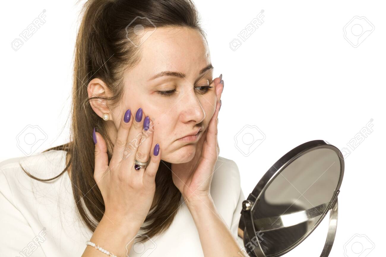 bored woman looking at herself in the mirror on white background - 141354733 bored woman looking at herself in the mirror on white background - 141354733
