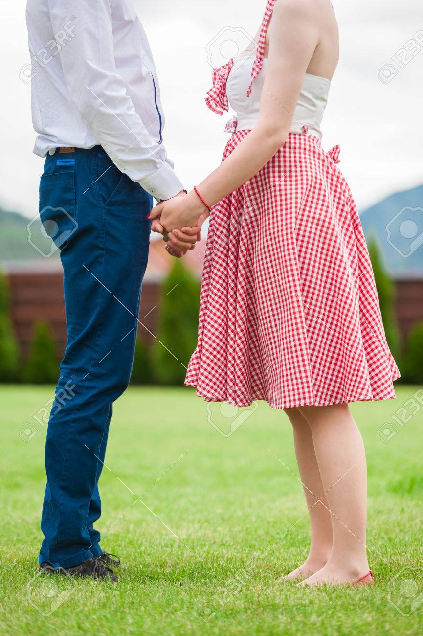 脚しか婚約写真 結婚式 ピクニック 晴れた日 ロマンチックな写真 ドレス ヴィンテージ色をピンで女の子の顔なしの前に 草の中のカップル の写真素材 画像 素材 Image