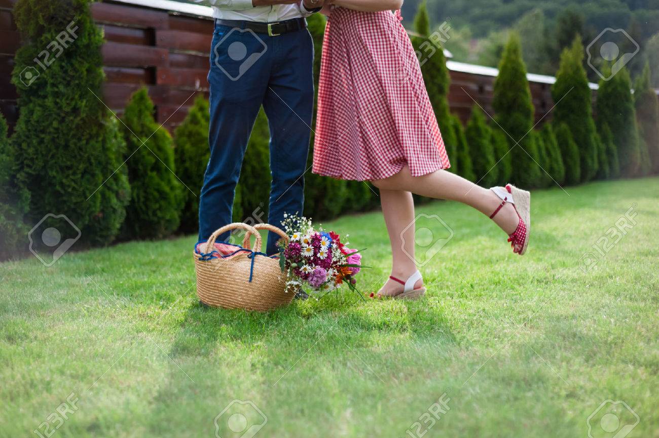 脚しか婚約写真 結婚式 ピクニック 晴れた日 ロマンチックな写真 ドレス ヴィンテージ色をピンで女の子の顔なしの前に 草の中のカップル の写真素材 画像 素材 Image