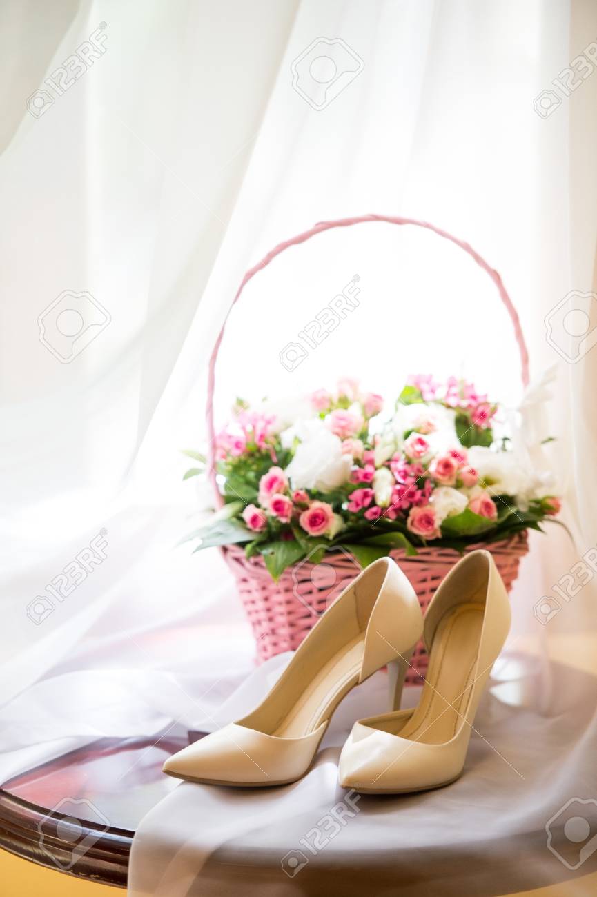 Wedding Shoes And A Basket Of Flowers On A Light Background