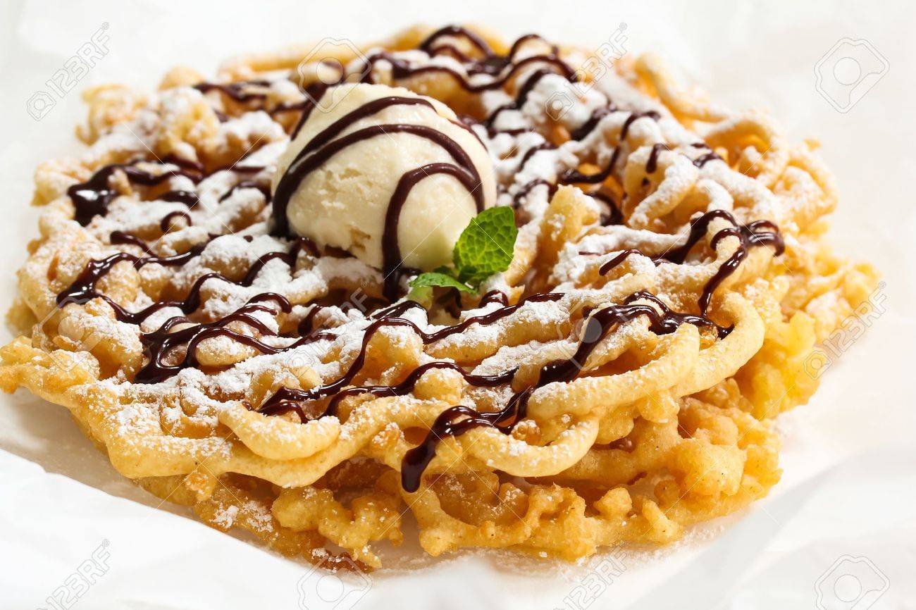 homemade funnel cake topped with ice cream powdered sugar and