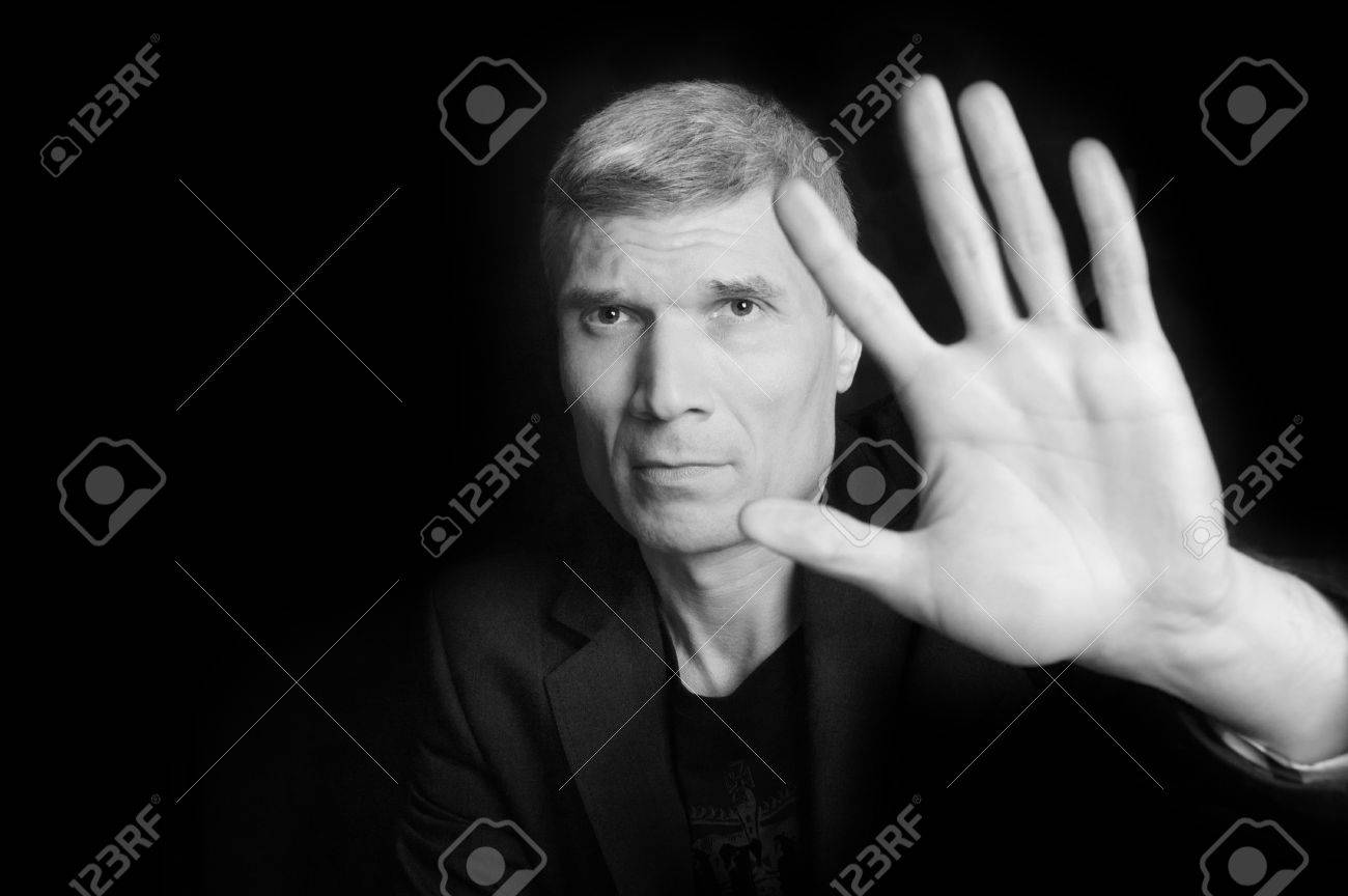 Homme Aux Cheveux Gris En Costume Et T Shirt Noir à Lâge De Quarante Six Ans Avec La Main En Regardant La Caméra Sur Un Noir