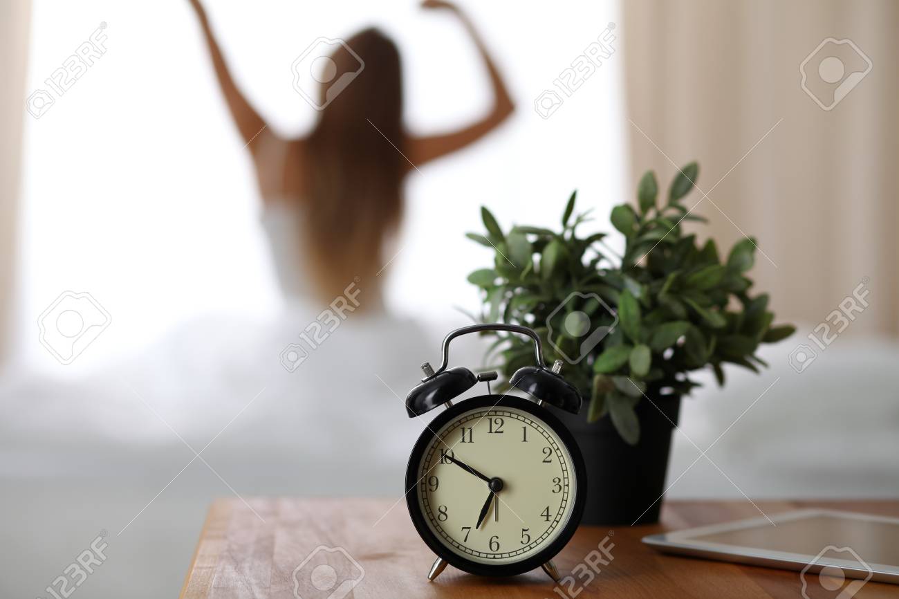 bedside table alarm clock white alarm clock standing on bedside table has already rung early morning to wake up woman in clock standing on bedside table has already rung early stock bedside table alarm clock white alarm clock standing on bedside table has already rung early morning to wake up woman in clock standing on bedside table has already rung early stock