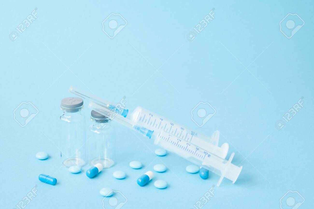 Pills and medical injection on blue background. Creative idea for health care cost, drugstore, health insurance and pharmaceutical company business concept. Copy space - 124423218 Pills and medical injection on blue background. Creative idea for health care cost, drugstore, health insurance and pharmaceutical company business concept. Copy space - 124423218