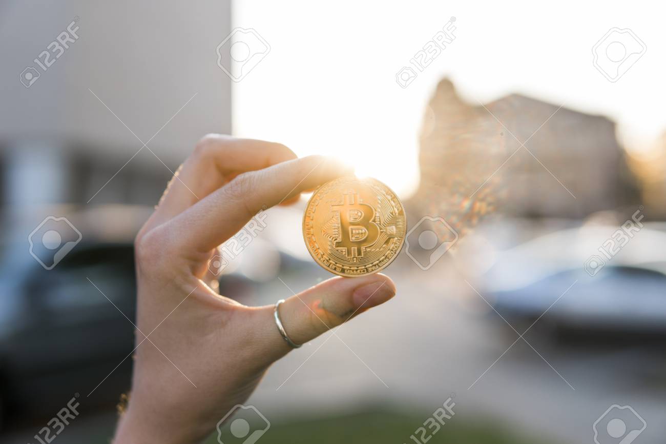 Golden Bitcoin Munt In De Hand Op Een Wazige Zonsondergang Achtergrond.  Hand Houden Van Een Crypto Valuta Virtuele Geld. Bussiness, Commerciële,  Uitwisseling, Digitaal Geld. Royalty-Vrije Foto, Plaatjes, Beelden en Stock  Fotografie. Image