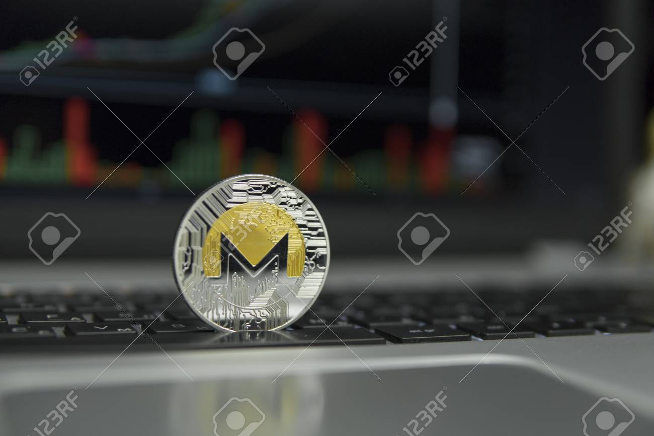 Moneda De Oro Y Plata De Monero En Un Teclado Negro De Portátil Plateado Y  Gráfico De Diagrama En Una Pantalla Como Fondo. Concepto De Criptomoneda.  Minería De Ethereums Negocio En Línea.