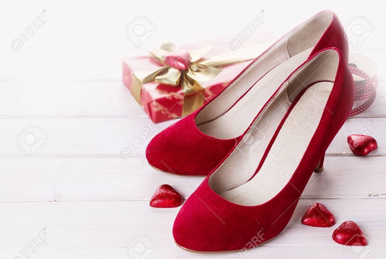 Valentine day items , pair of red shoes, gift box and red chocolate..