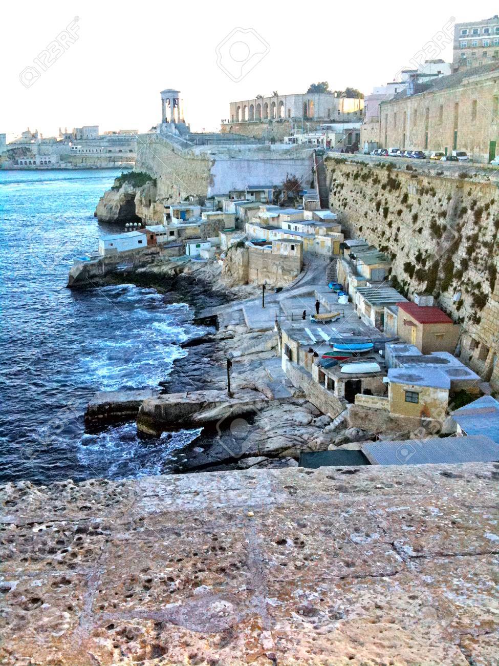 A small fishing town nestled in a natural harbor somewhere in Malta - 34392176 A small fishing town nestled in a natural harbor somewhere in Malta - 34392176