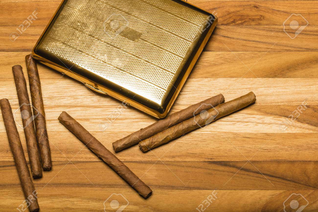 チーク木材の背景に小さなキューバのシガリロと真鍮製シガレット ケース の写真素材 画像素材 Image
