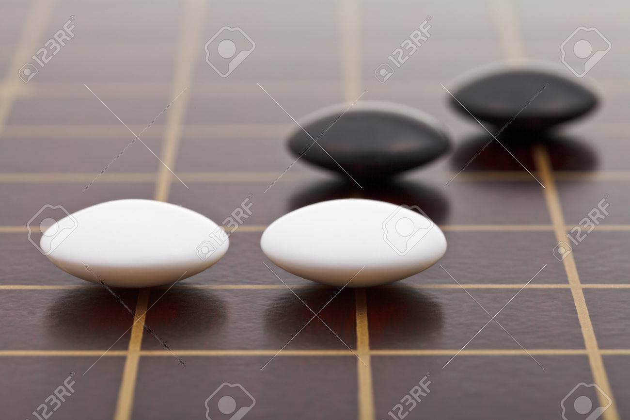 position of few stones during go game playing on wooden board close up - 26863727 position of few stones during go game playing on wooden board close up - 26863727