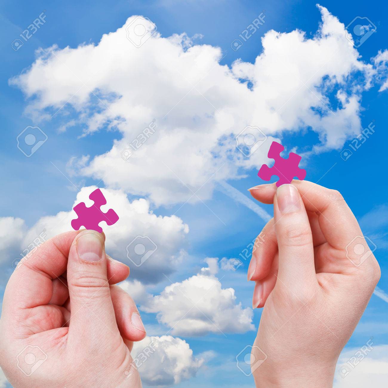 白い雲と青い空を背景に 小さなパズルのピースと男性と女性の手 の写真素材 画像素材 Image