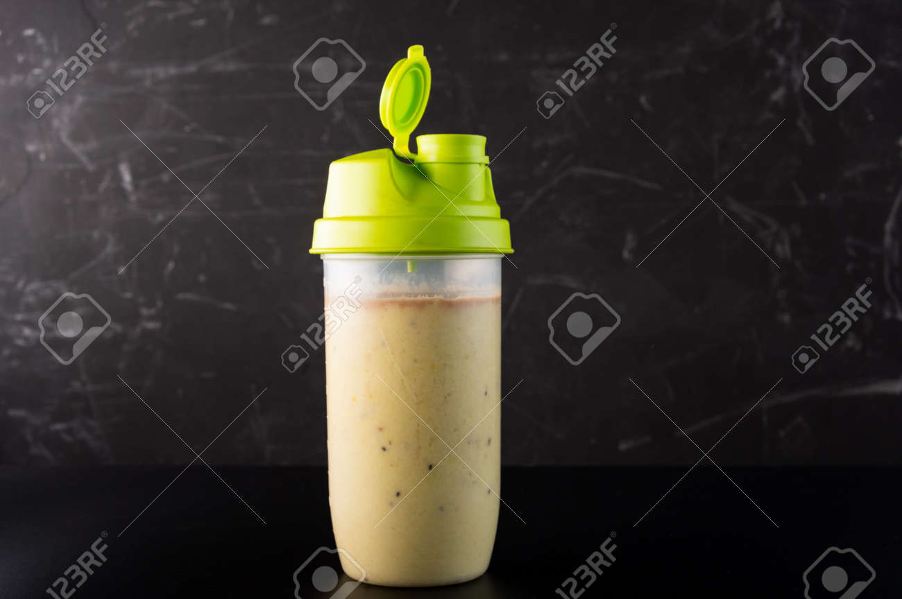Shaker with fruit and protein drink. Shaker isolate on a dark background. Front view. - 167153439 Shaker with fruit and protein drink. Shaker isolate on a dark background. Front view. - 167153439