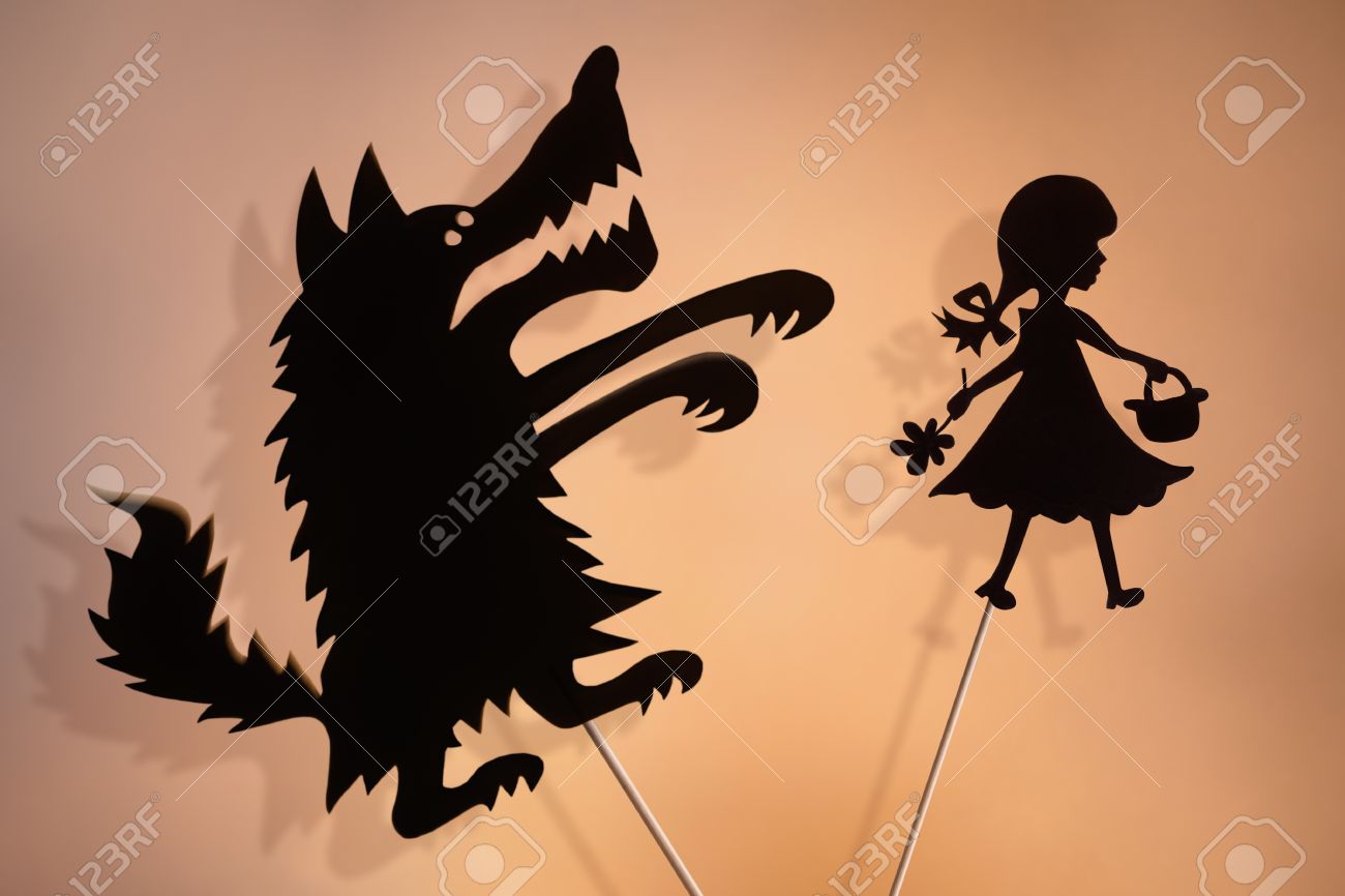 Little Red Riding Hood and the Big Bad Wolf shadow puppets and their shades on the soft glowing screen of shadow theater. - 54478506 Little Red Riding Hood and the Big Bad Wolf shadow puppets and their shades on the soft glowing screen of shadow theater. - 54478506