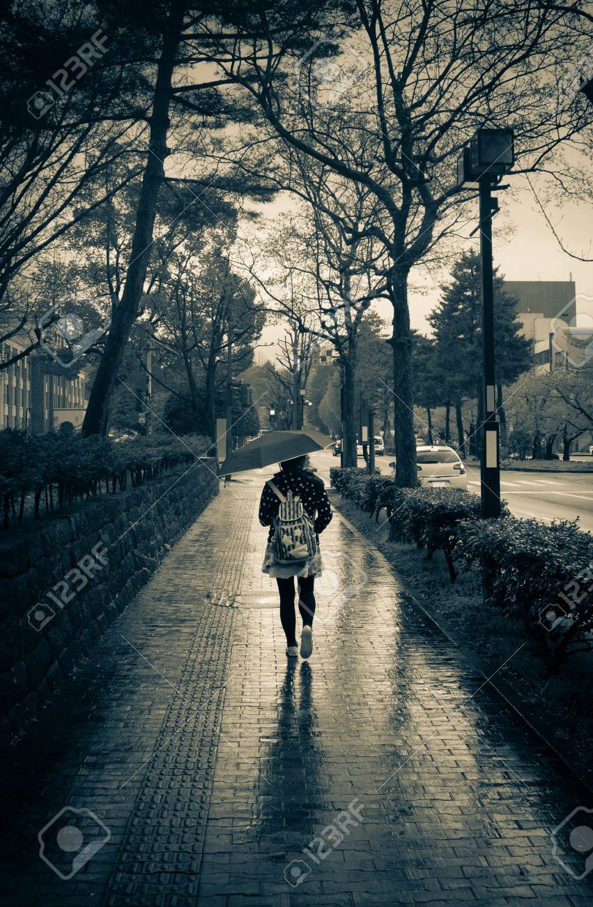 girl walking alone in rain