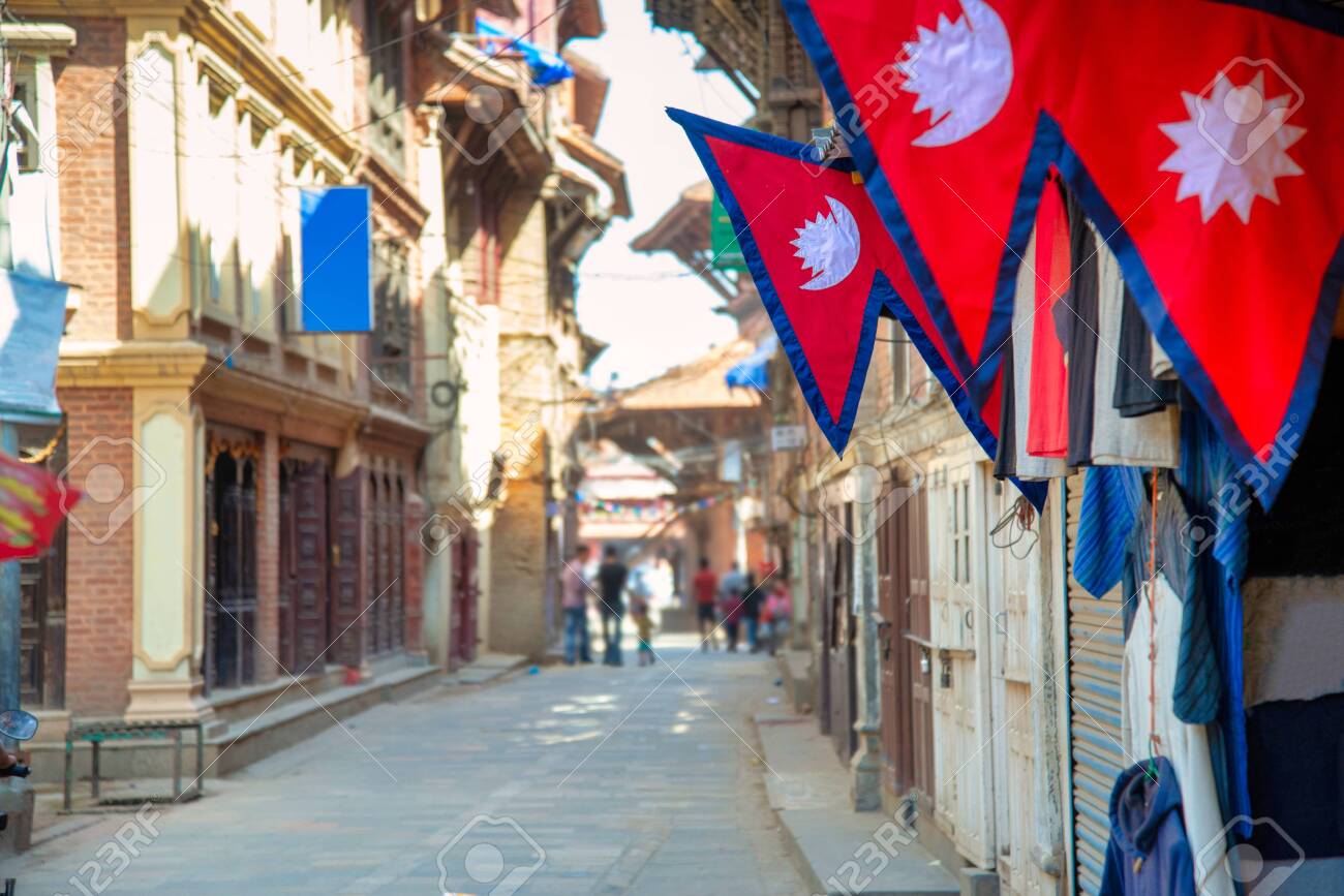 The Nepal national flag in foreground decoration in front of nepali house and the background is perspective of village in Kathmandu Nepal. - 128411959 The Nepal national flag in foreground decoration in front of nepali house and the background is perspective of village in Kathmandu Nepal. - 128411959