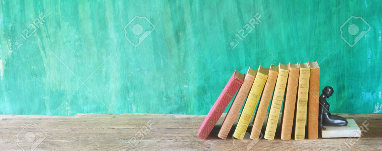 Row Of Multicolored Hardback Books And An Old Bookstand Reading