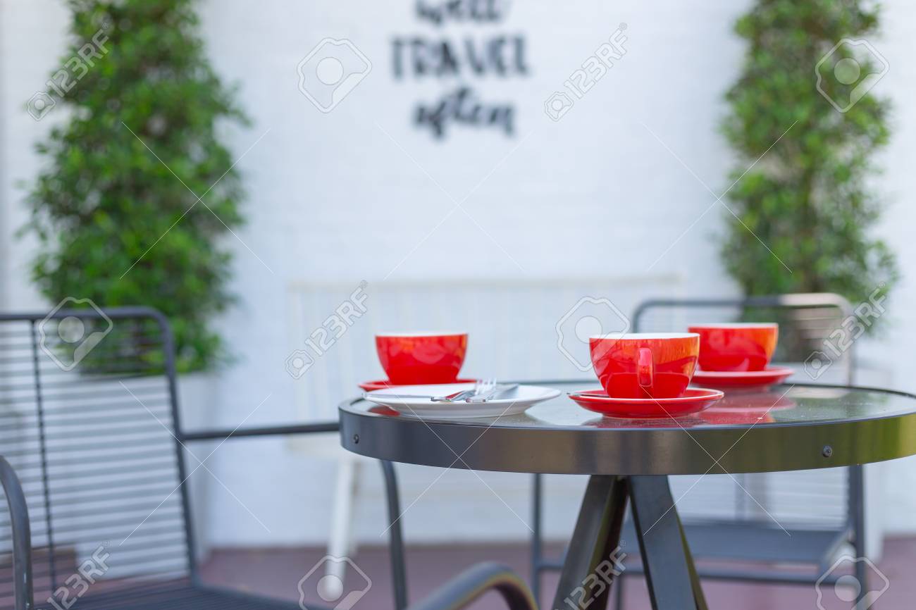 Red Coffee Mug Placed On A Table In A Coffee Shop With White